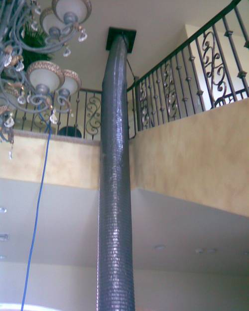 Duct cleaning hose connected to air duct vent